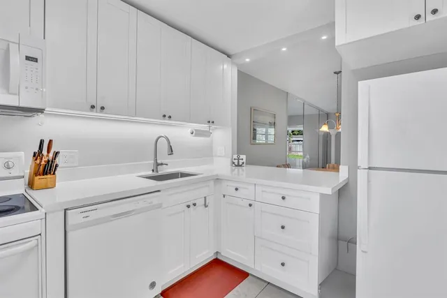 a kitchen with white cabinets and sink