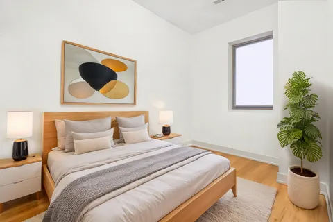 a bedroom with a bed and a potted plant