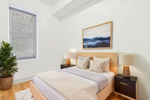 a bedroom with a bed and a potted plant