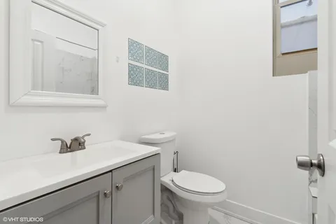 a bathroom with a sink a toilet and mirror