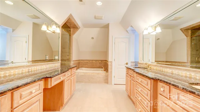 a spacious bathroom with a granite countertop sink and a large mirror