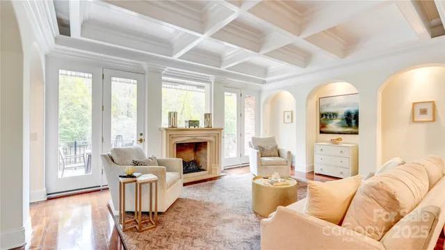 a living room with furniture a fireplace and a large window