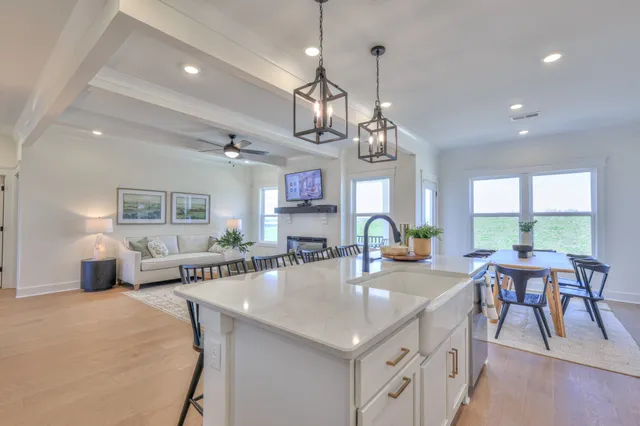 a large kitchen with a counter space a sink appliances and dining table