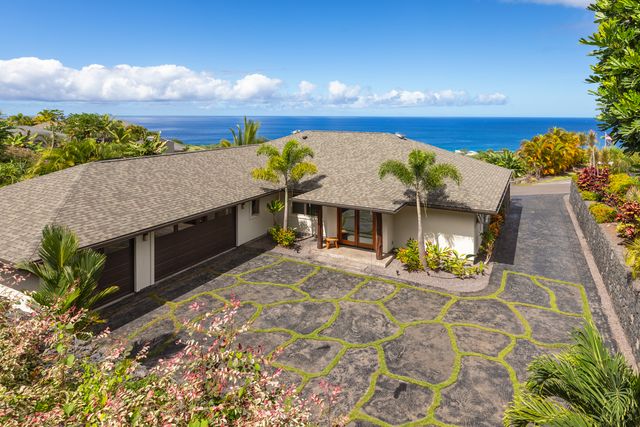 a living room with furniture a floor to ceiling window and wooden floor