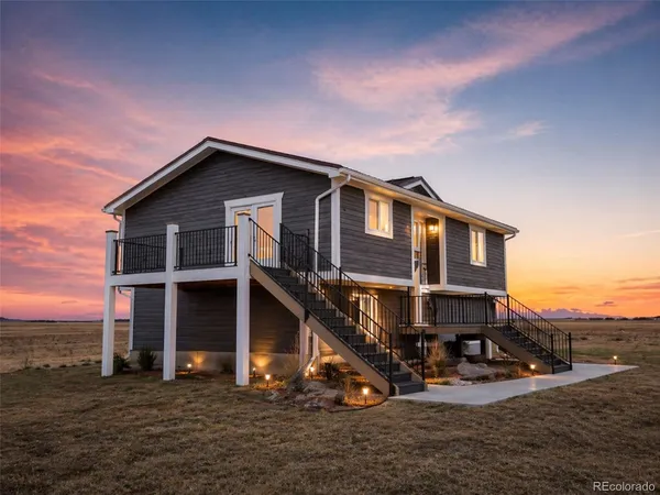 a view of a house with a yard and seating space