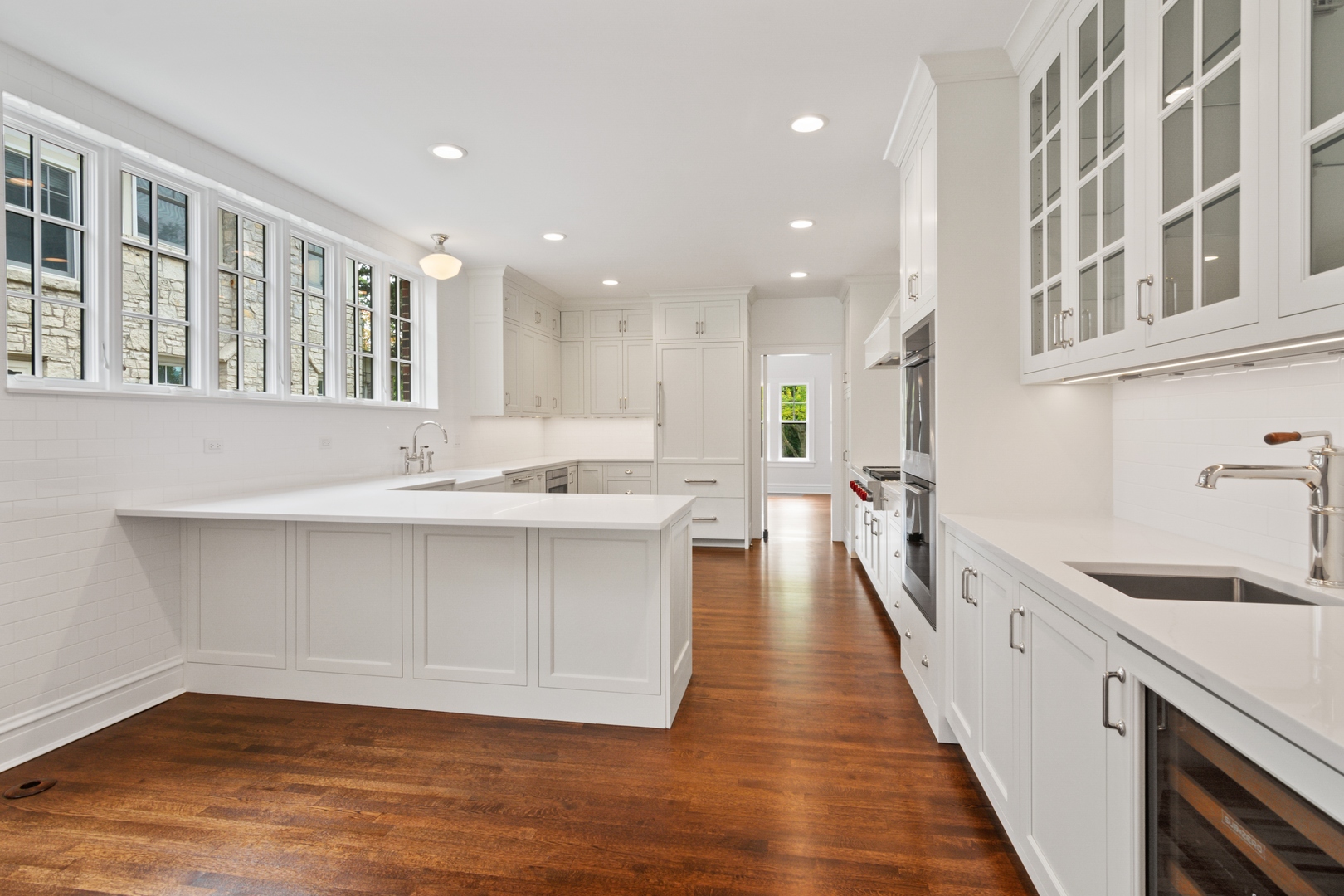 1045 Pine Street Winnetka, IL 60093 - Photo 12 of 38 a open kitchen with kitchen island a sink appliances wooden floor and a counter top space