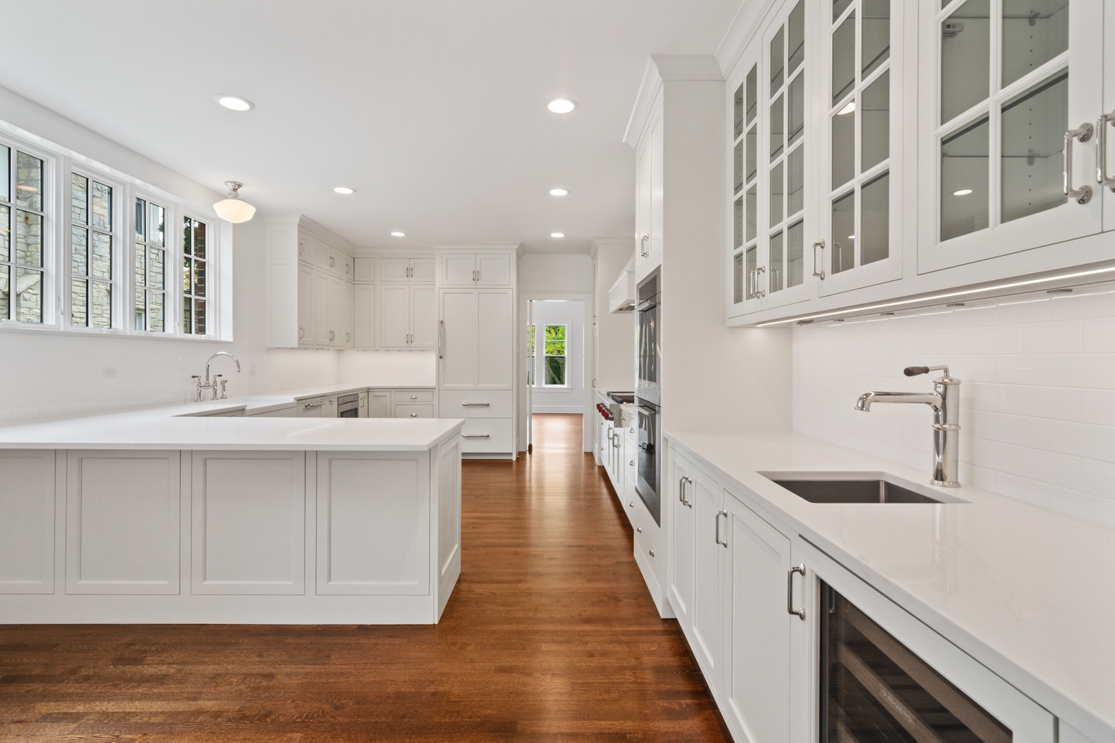 1045 Pine Street Winnetka, IL 60093 - Photo 14 of 38 a large white kitchen with a sink and cabinets