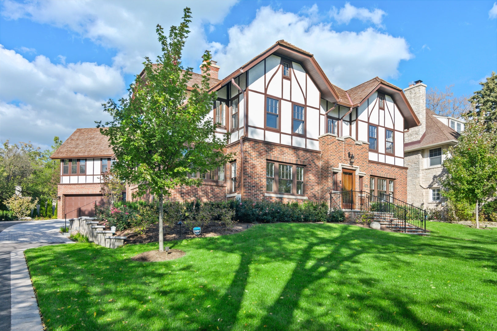 1045 Pine Street Winnetka, IL 60093 - Photo 3 of 38 a view of a big yard in front of a brick house with a large tree