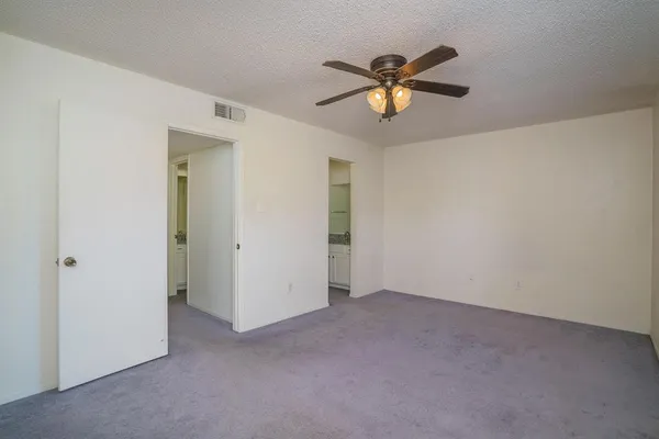 a view of an empty room with a ceiling fan