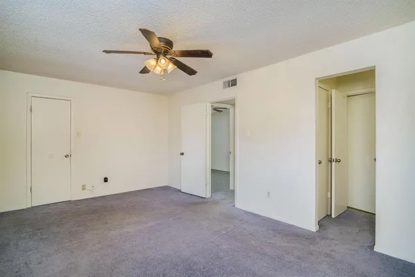 a view of an empty room with a ceiling fan