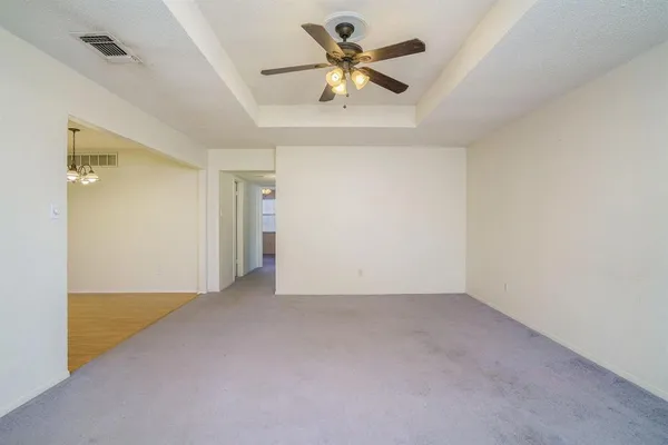 an empty room with closet and a chandelier fan