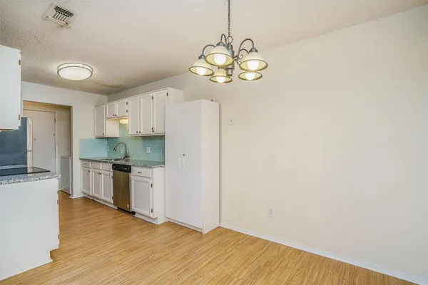 a view of a kitchen with a sink a refrigerator freezer a stove top oven with wooden floor