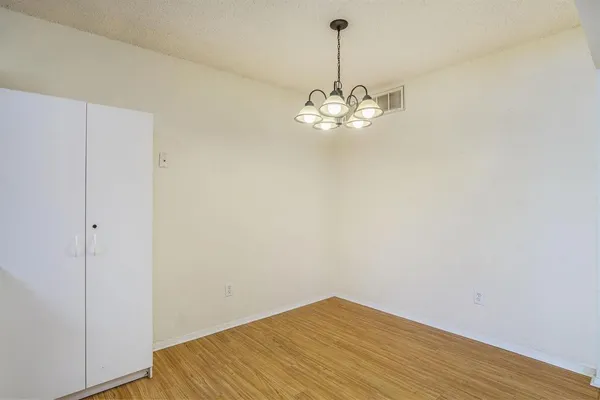 a view of a room with a wooden floor and chandelier