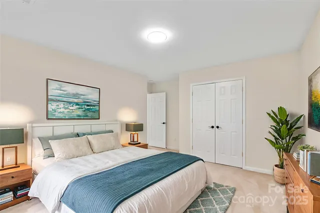 a bedroom with a bed and a painting on the wall