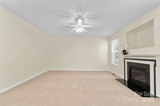 a view of empty room with fan and fireplace