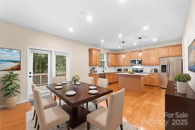 a open dining room with kitchen island a table and chairs in it