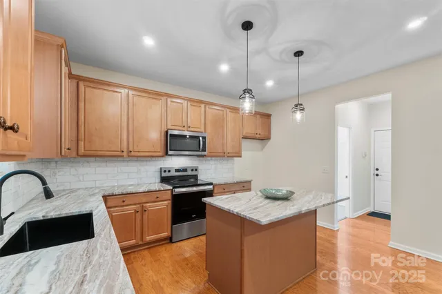 a kitchen with granite countertop a sink a counter space appliances and cabinets
