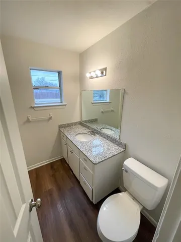 a bathroom with a granite countertop toilet sink and mirror