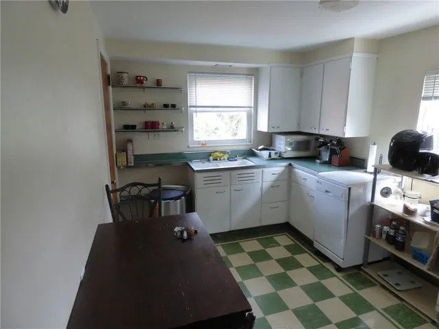 a kitchen with a sink a stove a window and cabinets