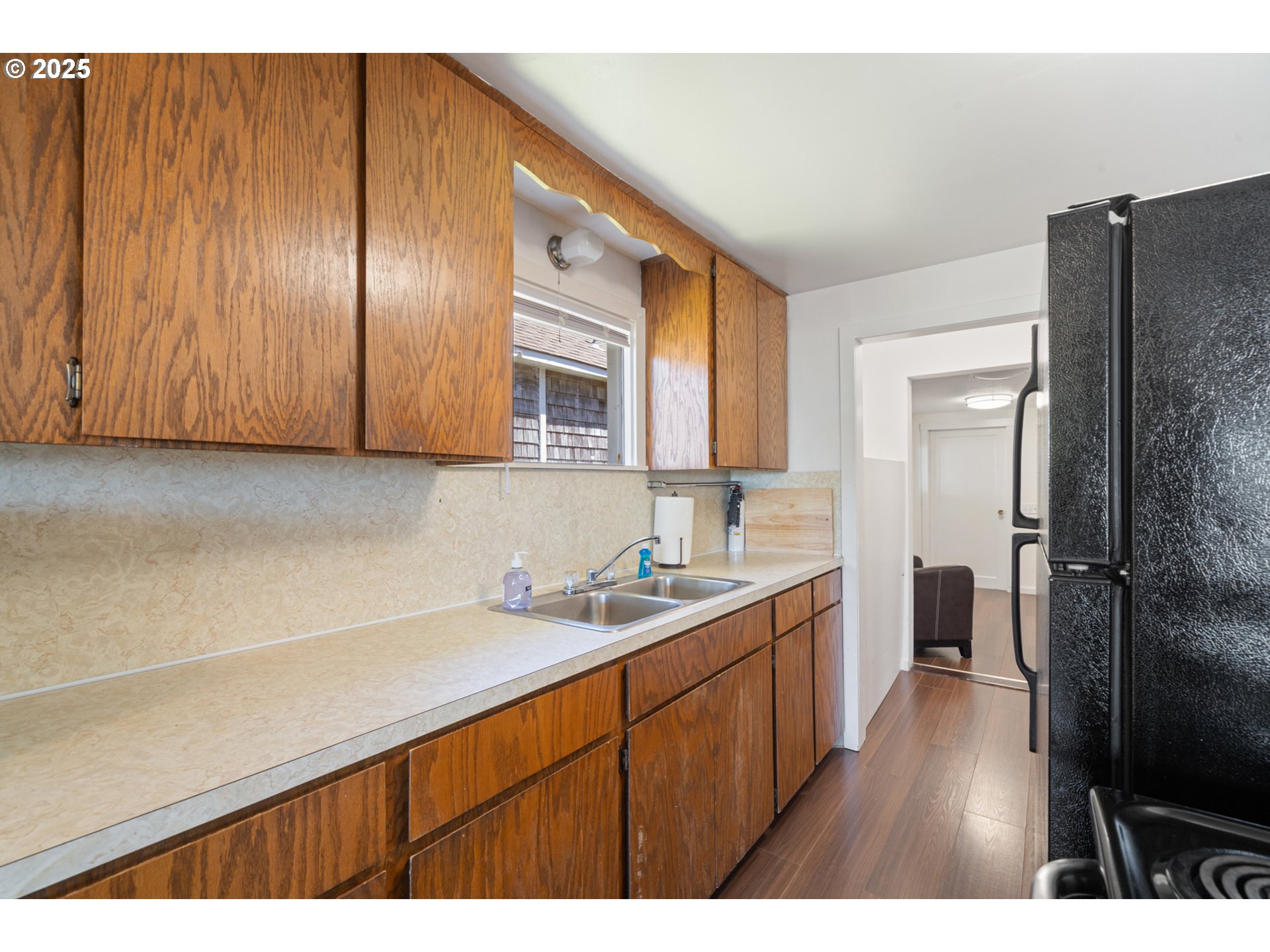 1195 3rd Street Netarts, OR 97141 - Photo 19 of 35 a kitchen with a sink a refrigerator and wooden cabinets