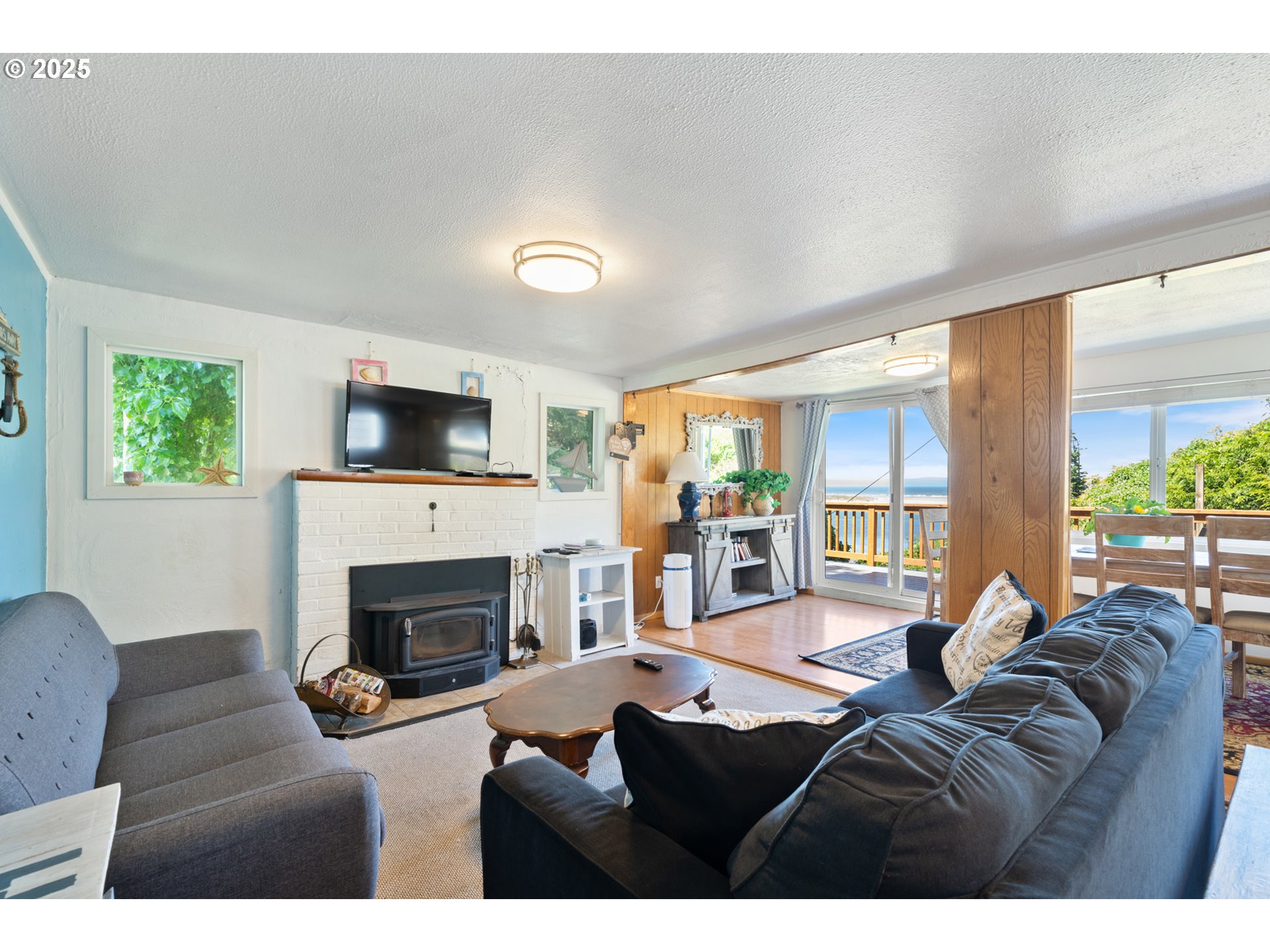 1195 3rd Street Netarts, OR 97141 - Photo 5 of 35 a living room with furniture a large window and a fireplace