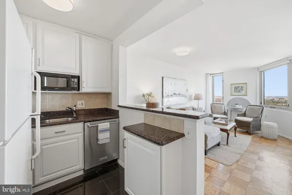 a kitchen with granite countertop a sink stove and cabinets