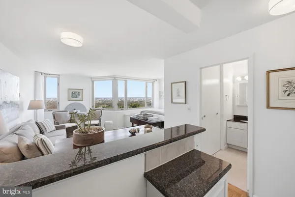 a kitchen with granite countertop white cabinets and white appliances