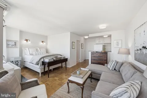 a bedroom with a bed couch and a window