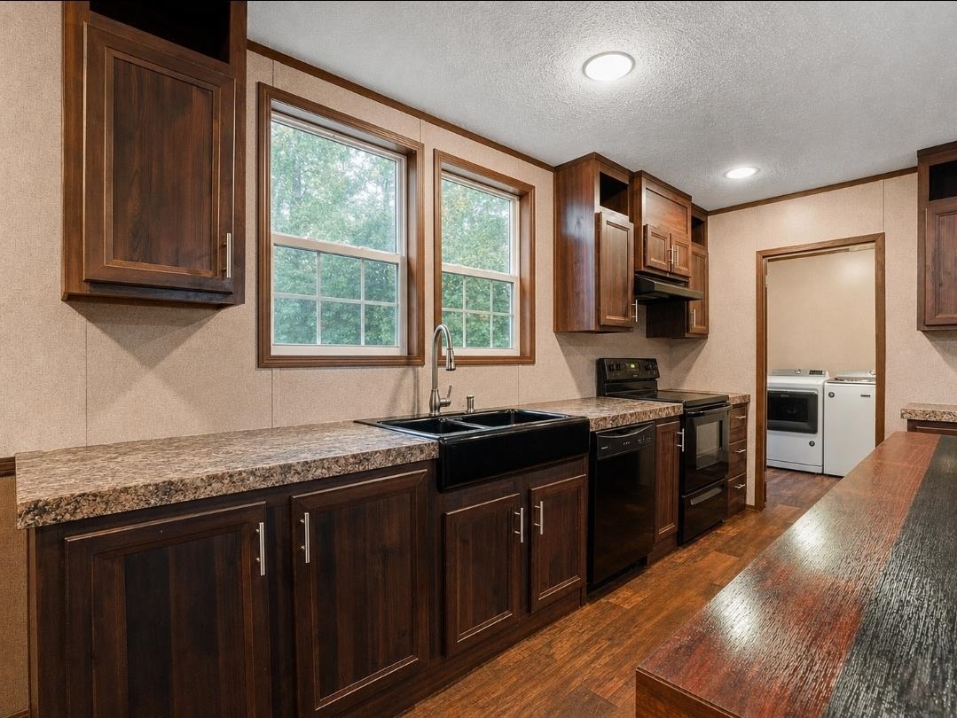 3779 Dancyville Road Stanton, TN 38069 - Photo 14 of 22 Kitchen featuring rich wood-finish cabinetry, granite-look countertops, and a black farmhouse-style sink with a modern faucet