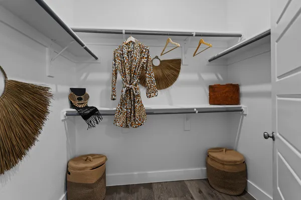 a view of walk in closet with clothes and shoes