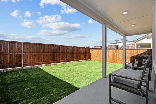 a view of a backyard with wooden fence