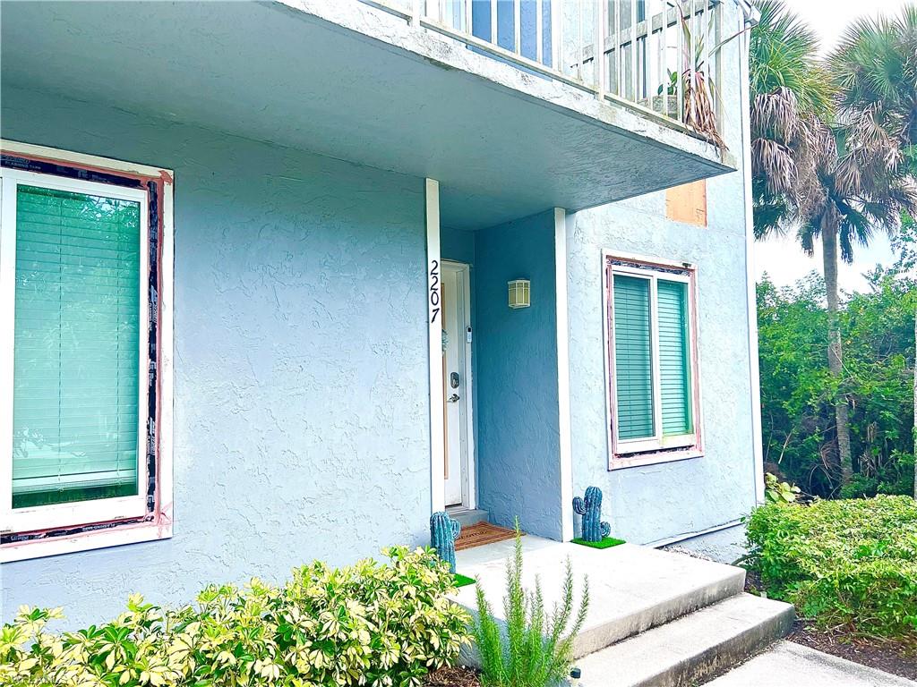 2207 San Marco Road, Unit 4104 Marco Island, FL 34145 - Photo 18 of 21 a front view of a house with a yard