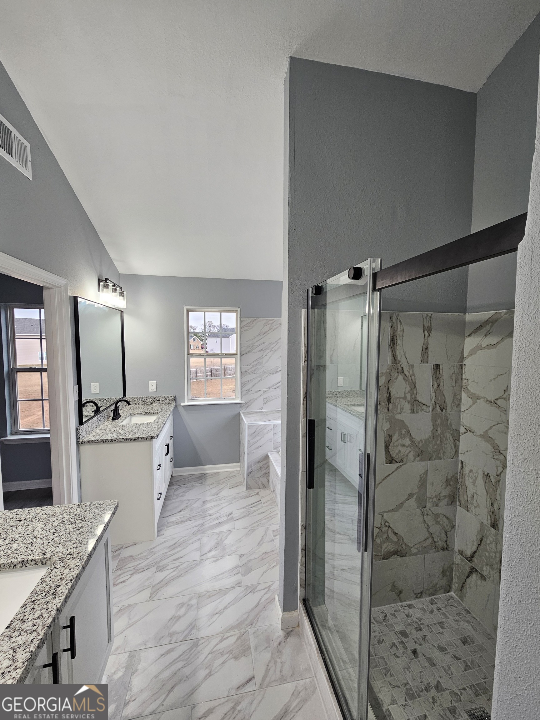 248 Sky Hawk Lane Macon, GA 31216 - Photo 3 of 6 a large bathroom with a granite countertop sink a toilet a mirror and shower