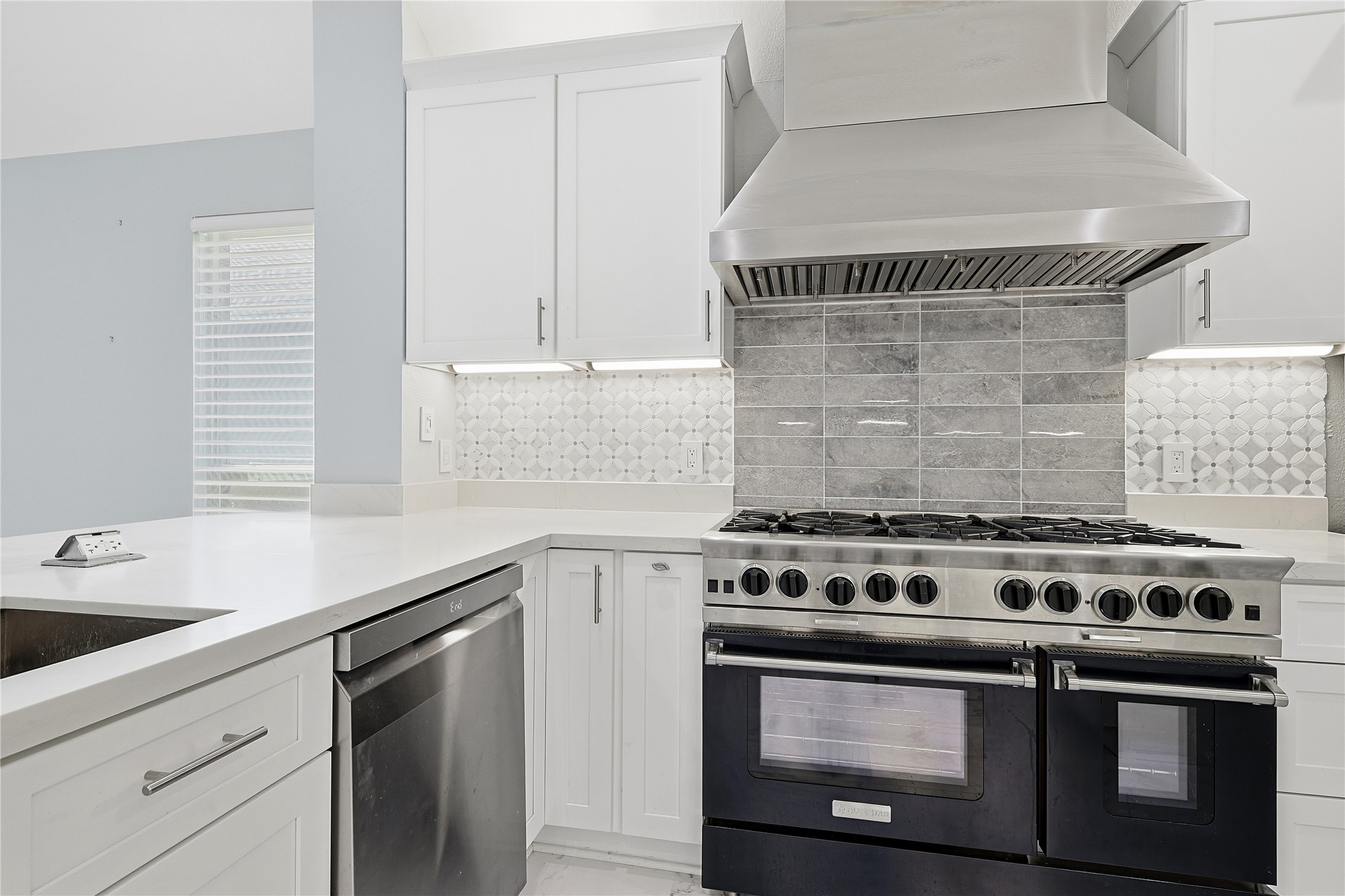 962 Oak Falls Drive Conroe, TX 77378 - Photo 11 of 28 a kitchen with a stove and white cabinets