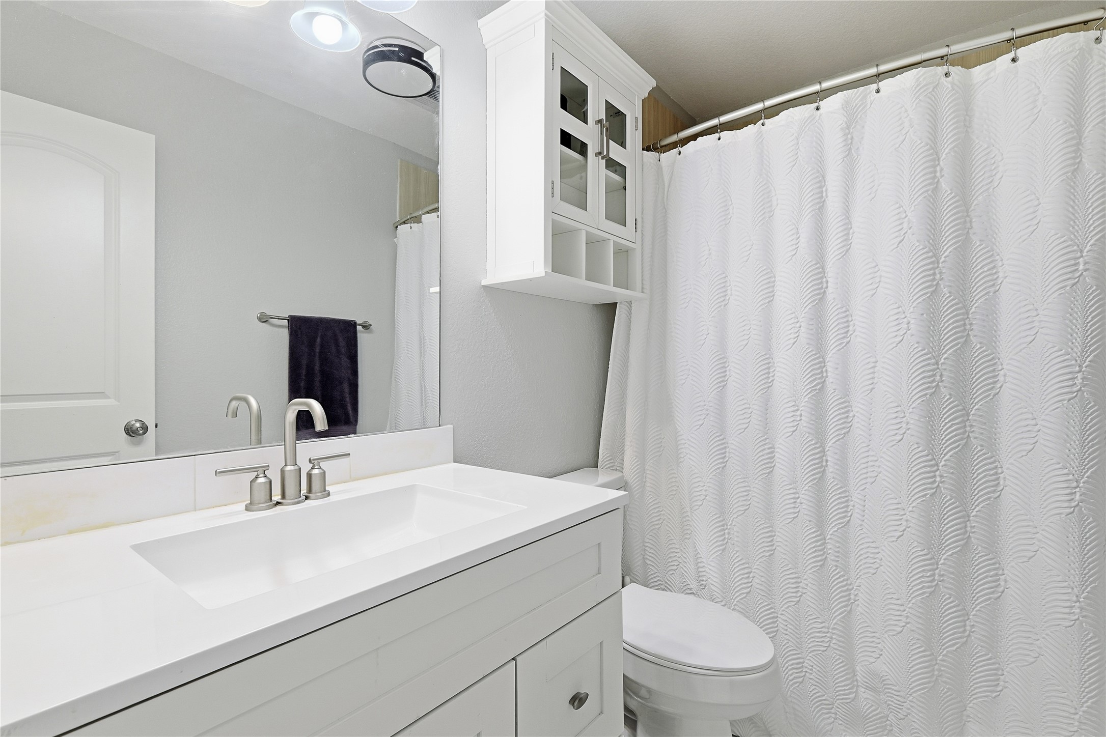 962 Oak Falls Drive Conroe, TX 77378 - Photo 19 of 28 a bathroom with a sink a toilet and shower curtain