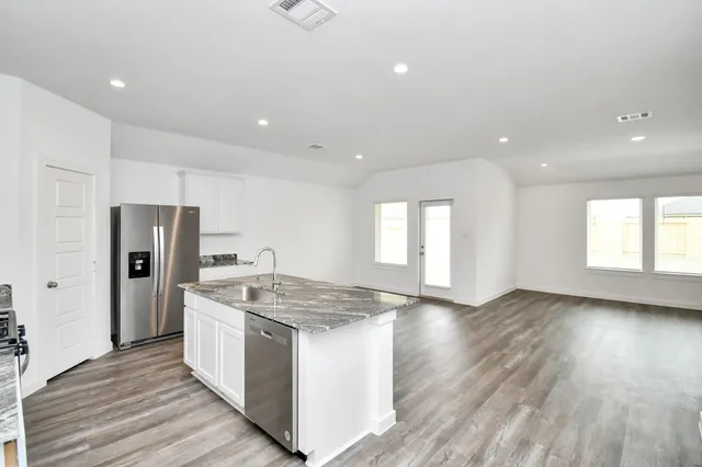 a kitchen with stainless steel appliances granite countertop a sink stove and refrigerator