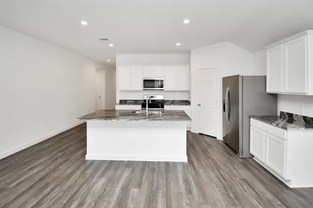 a kitchen with a sink a refrigerator and a stove top oven
