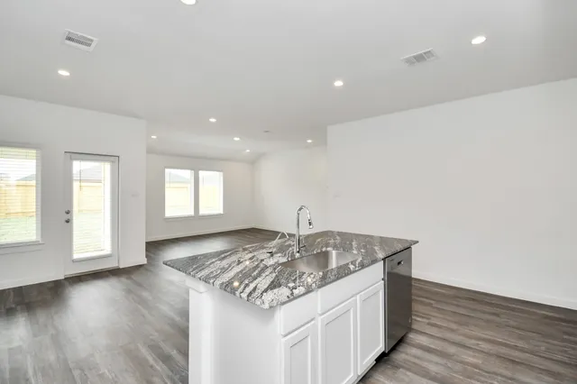 a kitchen with a sink and wooden floor
