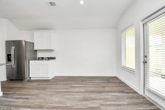 a view of a kitchen with wooden floor and electronic appliances