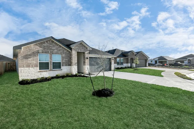 a front view of a house with a garden and yard