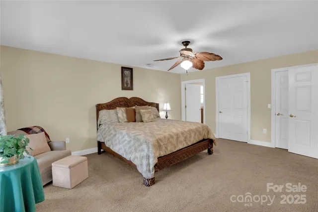 a spacious bedroom with a bed and a chandelier