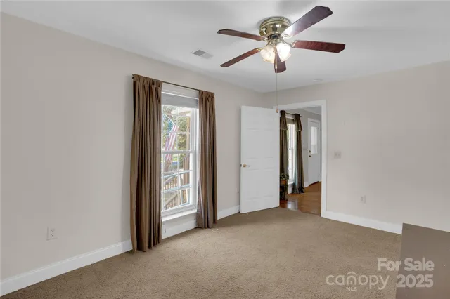 an empty room with a ceiling fan and a window