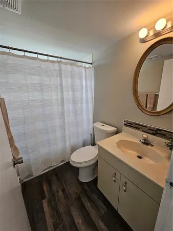 en empty room with wooden floor and fan