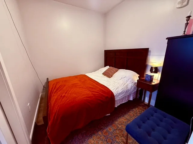 a bed sitting in a bedroom next to a window