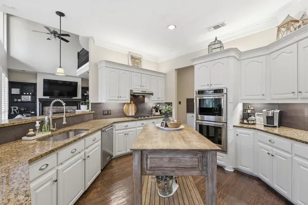 a kitchen with a sink a stove and cabinets