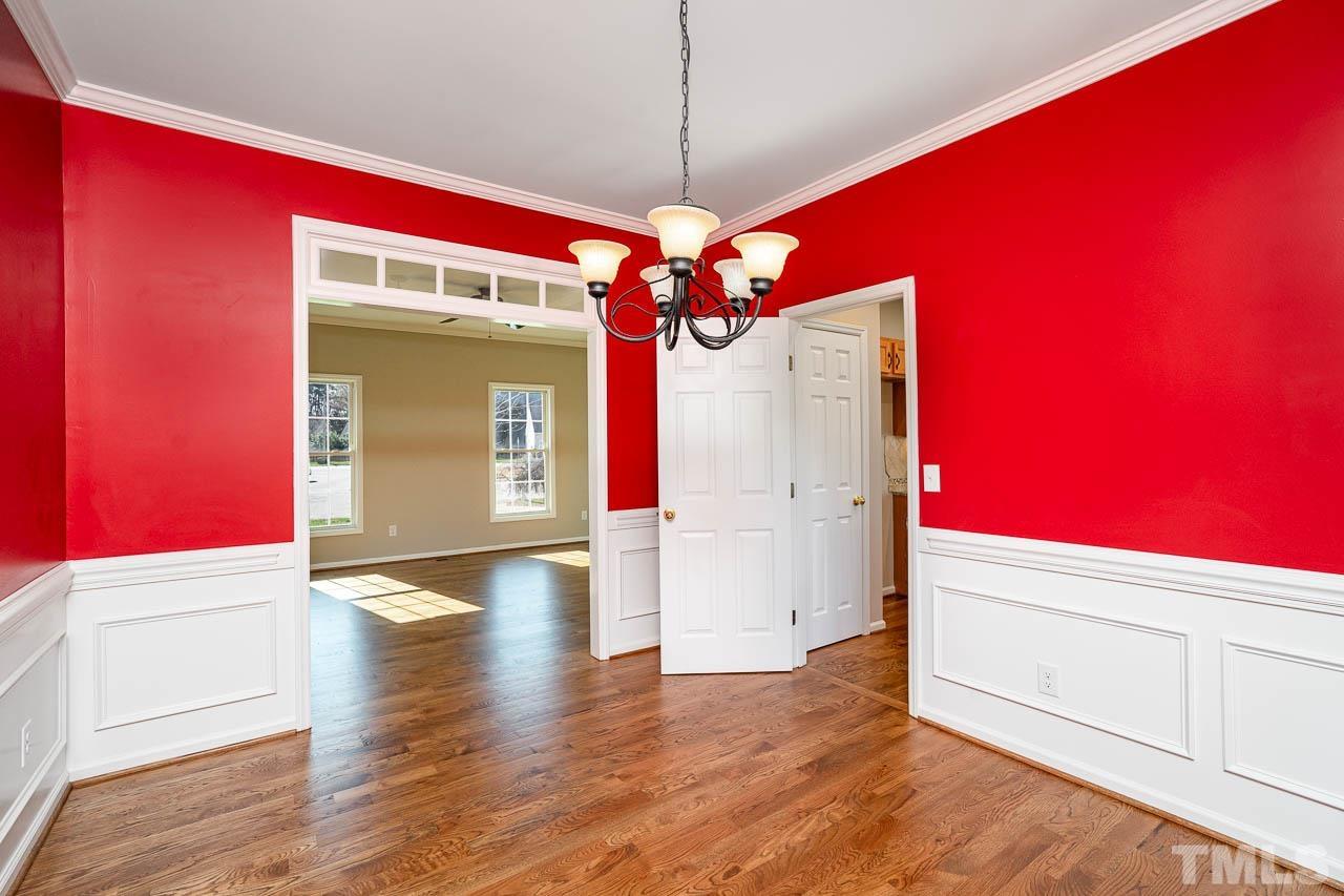 8409 Neuse Timbers Court Raleigh, NC 27616 - Photo 7 of 30 Large separate dining room with custom touches....transom above doorway, chair railing and wood floors.