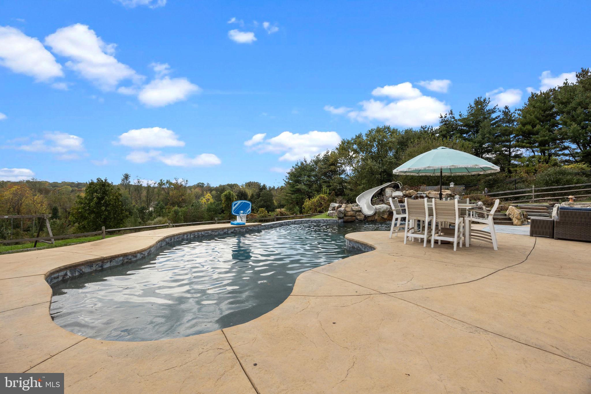 274 Pineville Road Newtown, PA 18940 - Photo 92 of 109 a view of a swimming pool with a table and chairs under an umbrella