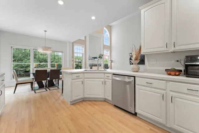 a kitchen with stainless steel appliances kitchen island granite countertop a sink a stove a microwave a refrigerator and cabinets