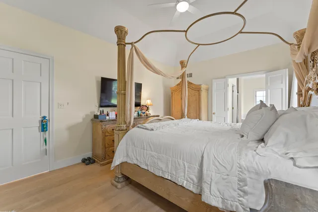a bedroom with a bed and a flat tv screen on dresser