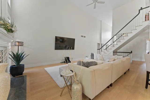 a kitchen with stainless steel appliances granite countertop a stove a sink a microwave a refrigerator white cabinets and wooden floor